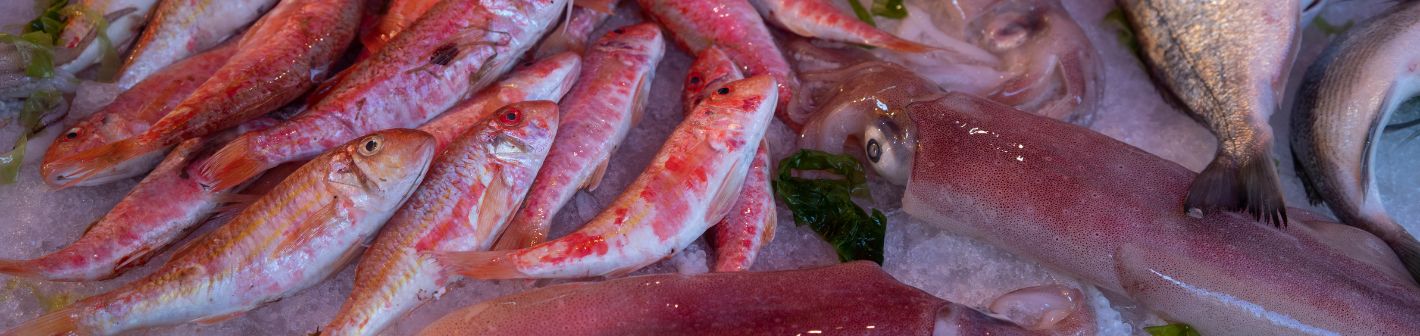 Marktstand mit frischem Obst, Gemüse und Fisch auf einem sizilianischen Markt